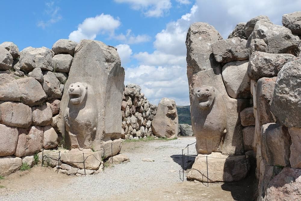 A stone gateway flanked by two carved lions in a reconstructed wall.